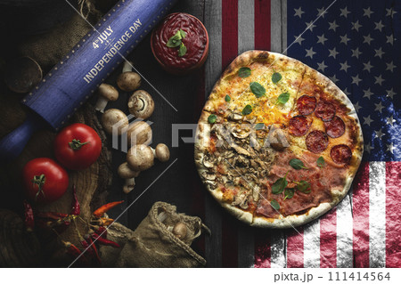 Pizza with different ingredients on the wooden table in the kitchen. American style pizza. Happy 4th of July. Independence day food concept Pizza with different ingredients on the wooden table in the kitchen. American style pizza. Happy 4th of July. Independence day food concept 111414564