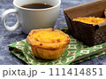 Lots of desserts Pastel de nata or Portuguese egg tart with a white cup of black coffee. Pastel de Belm is a small pie with a crispy puff pastry crust and a custard cream filling 111414851