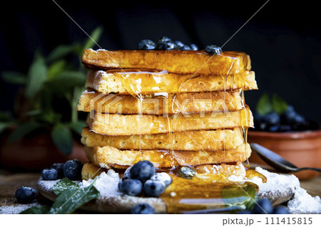 Waffles with fresh blueberries and honey on the rustic table. Freshly made Belgian waffles Waffles with fresh blueberries and honey on the rustic table. Freshly made Belgian waffles 111415815