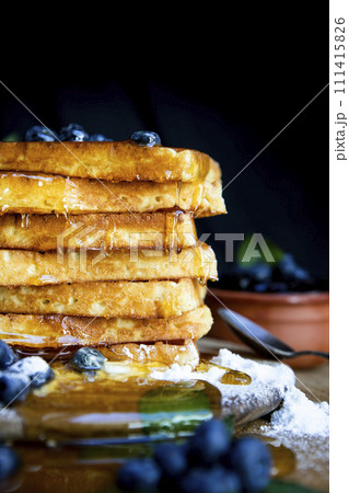 Waffles with fresh blueberries and honey on the rustic table. Freshly made Belgian waffles 111415826