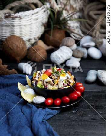 Fish salad with sardines, harringe, tuna, tomato, lemon, lettuce, cabbage, olives, beans, corn, carrotes and eggs on rustic kitchen table Fish salad with sardines, harringe, tuna, tomato, lemon, lettuce, cabbage, olives, beans, corn, carrotes and eggs on rustic kitchen table 111415975