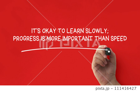 Hand writing It is okay to learn slowly affirmation on red cover background. Affirmation concept. Hand writing It is okay to learn slowly affirmation on red cover background. Affirmation concept. 111416427