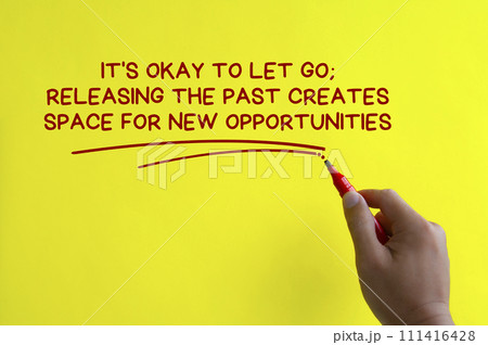 Hand writing It is okay to let go affirmation on yellow cover background. Affirmation concept. Hand writing It is okay to let go affirmation on yellow cover background. Affirmation concept. 111416428
