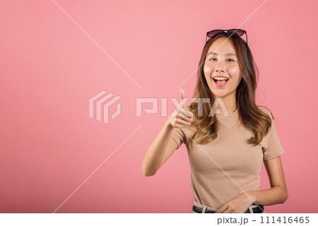 Portrait Asian beautiful young woman smiling she standing made finger thumbs up, Ok sign to agree studio shot isolated on pink background, Thai female successful like finger gesture with copy space Portrait Asian beautiful young woman smiling she standing made finger thumbs up, Ok sign to agree studio shot isolated on pink background, Thai female successful like finger gesture with copy space 111416465
