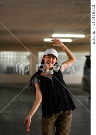 Smiling young woman breakdancing in underground parking lot .Concept of action, sport, youth lifestyle Smiling young woman breakdancing in underground parking lot .Concept of action, sport, youth lifestyle 111416812