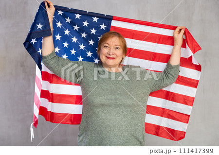 Cheerful senior woman standing confidently with american flag 111417399