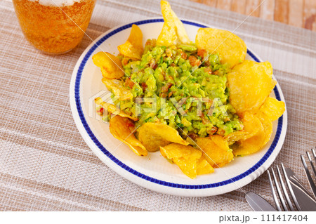 Mexican guacamole sauce with savory crispy chips 111417404