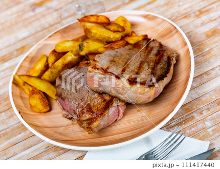 Delicious roasted veal chop served with potato Delicious roasted veal chop served with potato 111417440