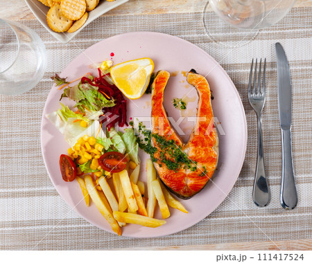 Salmon served with potatoes and vegetable salad Salmon served with potatoes and vegetable salad 111417524