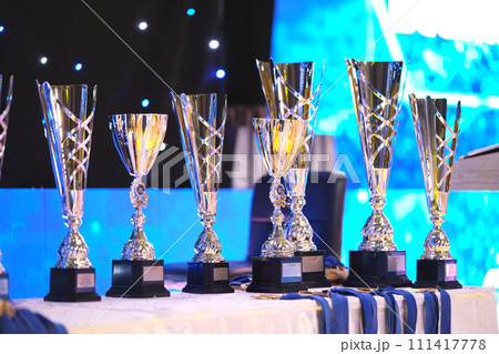 Close-up of golden trophies lined up at a dance event. Collection of trophies. Award cups close up 111417778