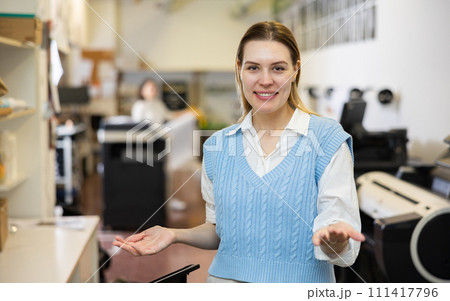 Friendly print shop employee invites customer to come inside 111417796