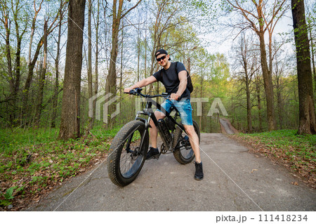 Man on a fatbike in the woods. Pleasant sports hobby. Concept of a healthy lifestyle. 111418234