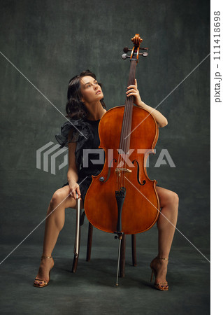 Beautiful woman, talented, passionate cellist looking upward, reflecting creativity and inspiration while playing. Catching inspiration 111418698