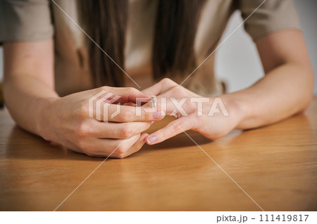 結婚指輪を外す女性の手 111419817