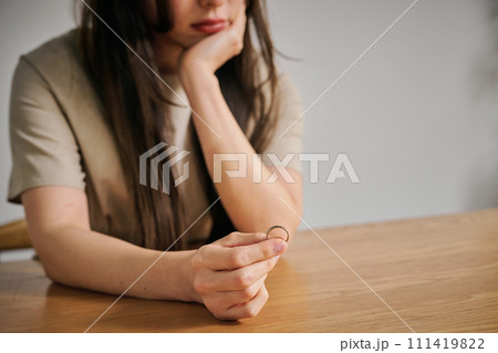 結婚指輪を外す30代女性 111419822