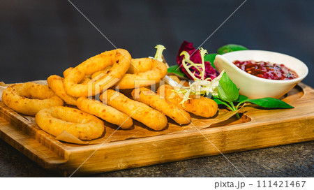 Homemade crunchy fried onion rings with tomato sauce 111421467