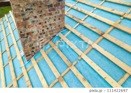 Aerial view of a wooden roof frame of brick house under construction. 111422697