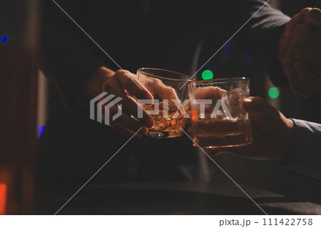 Celebration night, pour whiskey into a glass. Give to friends who come to celebrate 111422758