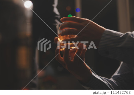 Celebration night, pour whiskey into a glass. Give to friends who come to celebrate 111422768