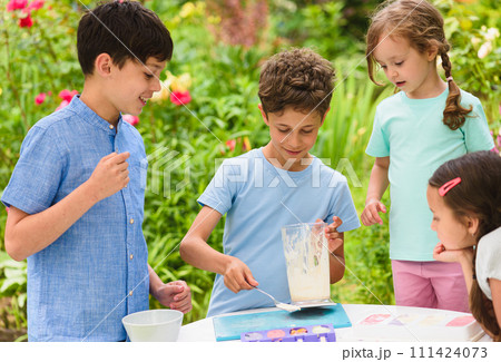 Group of children making homemade ice-cream at cooking masterclass Group of children making homemade ice-cream at cooking masterclass 111424073