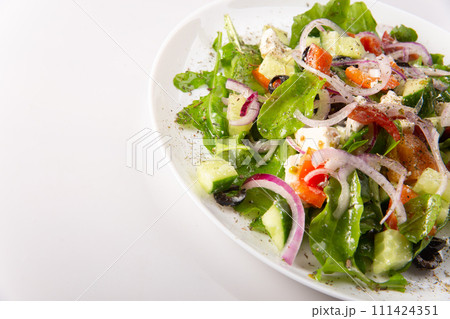 Traditional greek salad with fresh ingredients, feta cheese, olives, red tomatoes, cucumbers and greens Traditional greek salad with fresh ingredients, feta cheese, olives, red tomatoes, cucumbers and greens 111424351