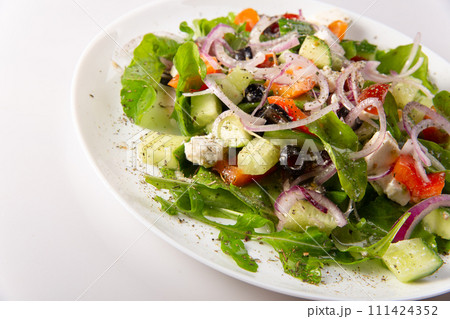 Traditional greek salad with fresh ingredients, feta cheese, olives, red tomatoes, cucumbers and greens Traditional greek salad with fresh ingredients, feta cheese, olives, red tomatoes, cucumbers and greens 111424352