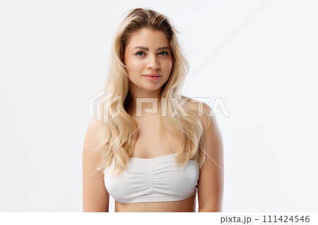 Beauty product advertising featuring model with clear skin and natural makeup to promote skincare items. Beautiful young woman against white background Beauty product advertising featuring model with clear skin and natural makeup to promote skincare items. Beautiful young woman against white background 111424546