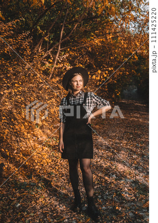 Hipster woman rejoices autumn in park, beautiful golden nature. Walking in park. 111425220