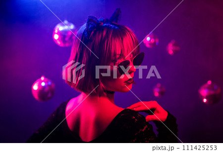 Portrait of young pretty woman neon light. Pussy cat costume for halloween party Portrait of young pretty woman neon light. Pussy cat costume for halloween party 111425253