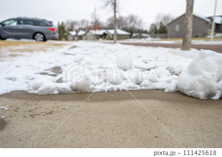 Residential sidewalk with section that has been cleared of snow next to a covered path. Residential sidewalk with section that has been cleared of snow next to a covered path. 111425618