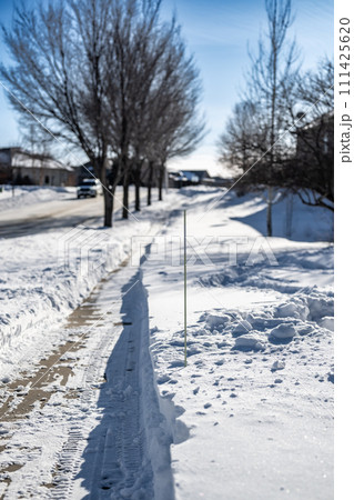 Sidewalk with edge markers used for snow blowing guides 111425620