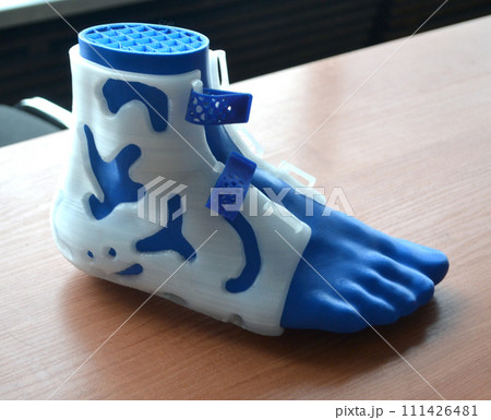Medicine splint corset prosthesis langet for foot and model human foot printed on 3D printer from molten plastic. Medical orthosis, fixator, plastic overlay for leg and human leg created on 3D printer Medicine splint corset prosthesis langet for foot and model human foot printed on 3D printer from molten plastic. Medical orthosis, fixator, plastic overlay for leg and human leg created on 3D printer 111426481