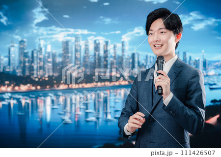 野外でマイクを使って話すスーツを着た男性 111426507