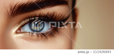 Close-up of female eyes on beige background. 111426893