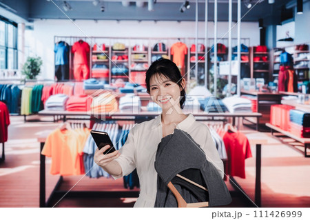 服屋さんで買い物をする若い女性 111426999