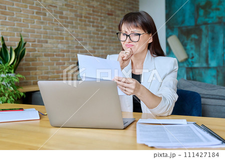 Upset sad business woman reading an official letter 111427184