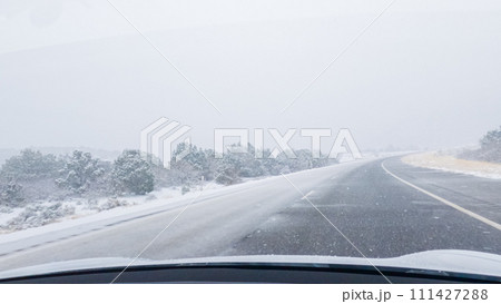 POV-Electric vehicle is captured deftly navigating the I-70 highway during a winter storm in Western Colorado. 111427288