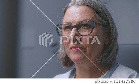 Close up shot of female doctor looking at monitor of sonography machine 111427586