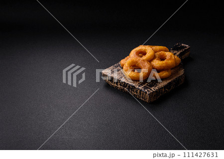 Delicious nutritious squid or onion rings deep fried with salt and spices Delicious nutritious squid or onion rings deep fried with salt and spices 111427631