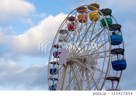 Colorful ferris wheel with a background of blue sky and clouds in the afternoon. Tibidabo, Barcelona Colorful ferris wheel with a background of blue sky and clouds in the afternoon. Tibidabo, Barcelona 111427854