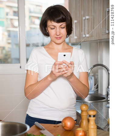 Woman reading news on her smartphone Woman reading news on her smartphone 111428769