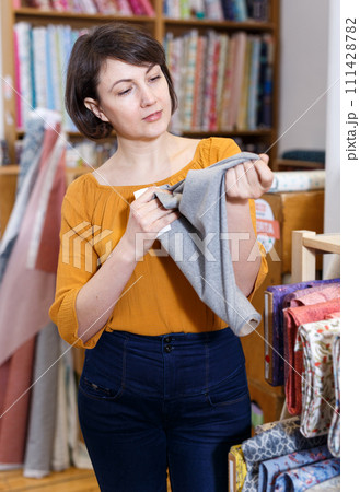 Woman choosing textiles in shop Woman choosing textiles in shop 111428782