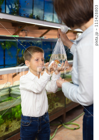 Boy with mom holding plastic bag with fish 111428803