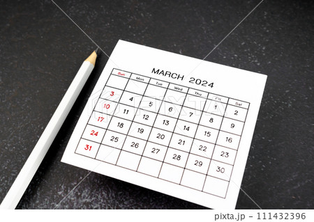 White calendar page for March 2024 and pencil on black. 111432396