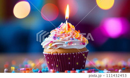 colorful cupcake with candle and sprinkles on blur festive background colorful cupcake with candle and sprinkles on blur festive background 111432453