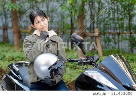 バイクに乗って悩む女性 バイクに乗って悩む女性 111433600