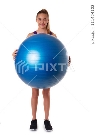 Slim and fit teen girl holding a swiss blue ball. Full length shot on white background. Slim and fit teen girl holding a swiss blue ball. Full length shot on white background. 111434102