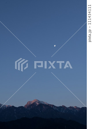 夜明けの空、南アルプス甲斐駒ケ岳の山並みに沈む有明の月 111434111