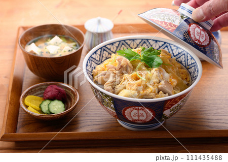 お盆にのせた親子丼と味噌汁と漬物 111435488