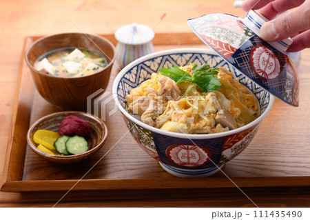 お盆にのせた親子丼と味噌汁と漬物 111435490
